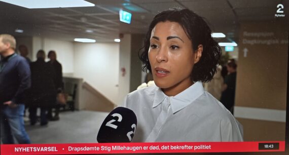 En kvinne med kort, krøllete hår snakker i en TV2 nyhetene-mikrofon i en gang, med uskarpe mennesker og Betanien sykehus-skilt i bakgrunnen. Nederst på skjermen vises en nyhetsticker.